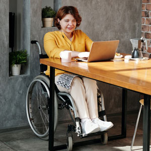 WE Medical Labs home bound program woman in wheelchair at home sitting at the table